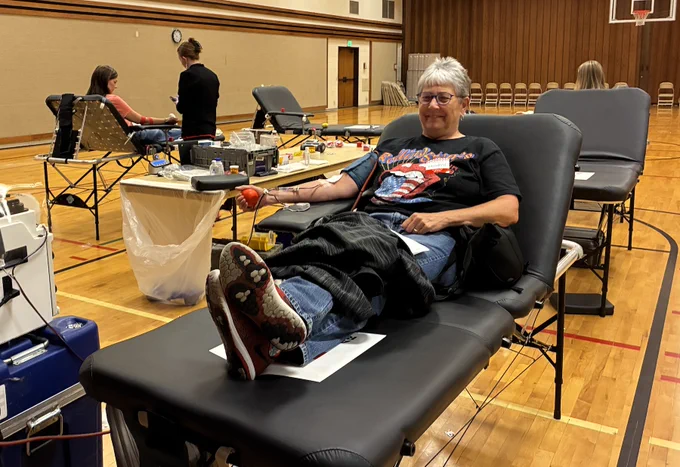 Woman on a table holding a stress ball, donating blood