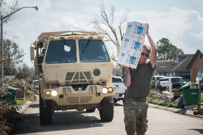 Oklahoma National Guardsman Spc. Bryan Stanley, a supply sergeant with the 1245th Transportation Company, 345th Combat Sustainment Support Battalion, 90th Troop Command, transports containers of water at a neighborhood in LaPlace, Louisiana, Sept. 7, 2021. Oklahoma National Guardsmen drove throughout neighborhoods to distribute supplies directly to Louisiana residents, allowing for essential aid to reach the local populace quickly. (Oklahoma National Guard photo by Senior Airman Alex Kaelke)