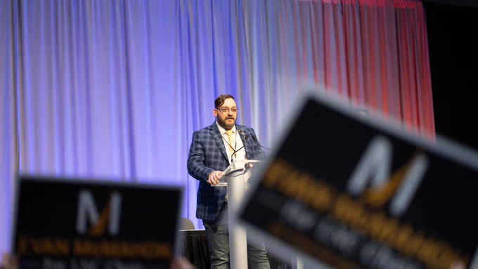 Image of Evan McMahon on stage at the 2026 Libertarian National Convention in Grand Rapids, MI after being elected chair of the Libertarian National Committee. 