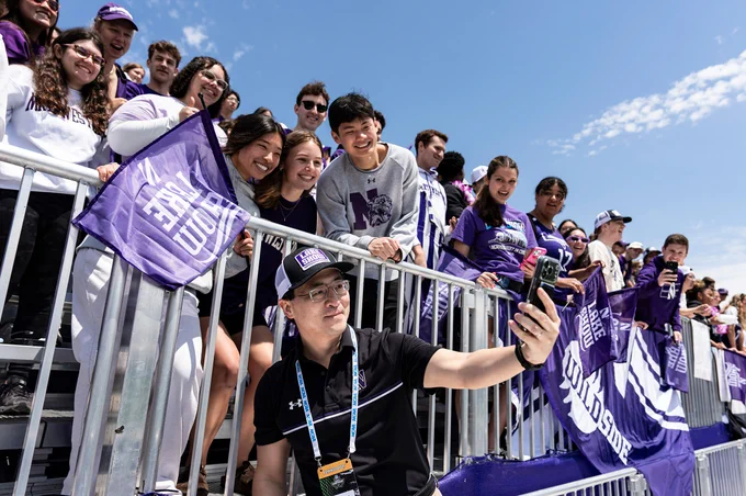 President-elect Mung Chiang takes a selfie with the Northwestern student section at the Lacrosse NCAA Championship.