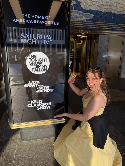 CSU student posing in front of Saturday Night Live and Kelly Clarkson Show signs in New York City. 
