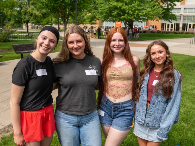 four new students smiling standing outside on a sunny day on BGSU campus