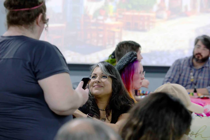 Pictured is a photo of U T A Libraries staff member Perla Vargas talking with a fellow staff member. 