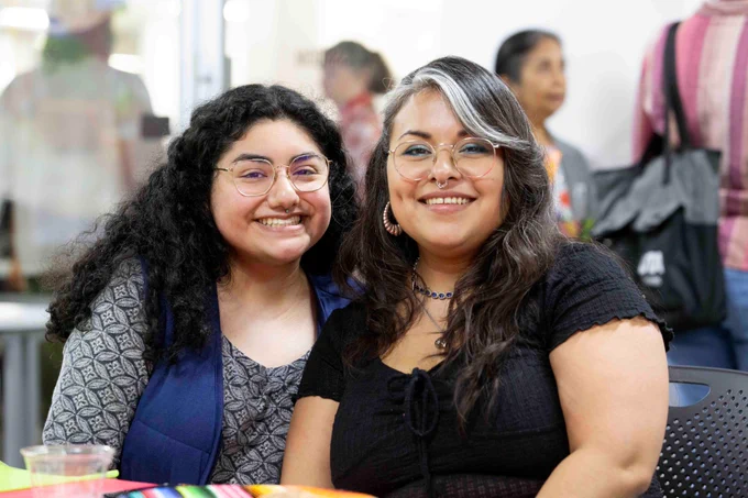 Pictured is a photo of U T A Libraries staff member Perla Vargas posing for a photo with a fellow staff member.