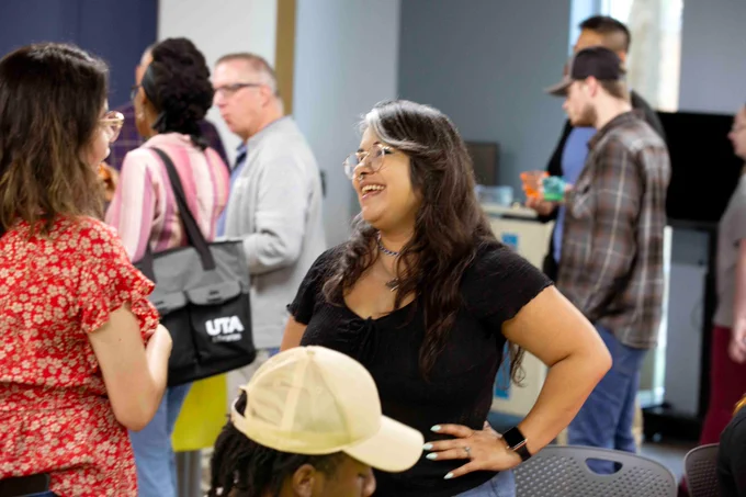 Pictured is a photo of U T A Libraries staff member Perla Vargas talking to a staff member at her goodbye party on May 27.