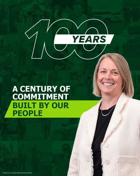 Vikki Blettner stands smiling in front of a collage. The background features the text "100 Years," "A Century of Commitment," and "Built by Our People" in bold lettering.