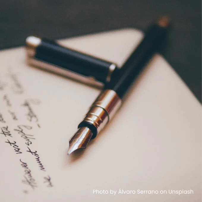 Image of a fountain pen resting on a page with writing in black ink. Photo by Álvaro Serrano on Unsplash.