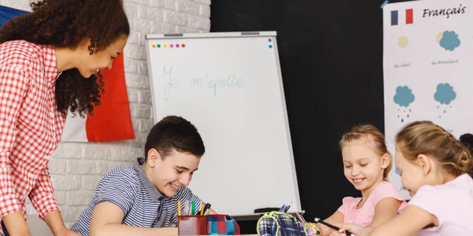 Mehrere Kinder in einem Klassenzimmer arbeiten zusammen an Schreibaufgaben.
