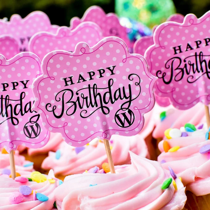 Cupcakes with Happy Birthday WordPress decorations on a stick. Photo by Robert Anderson on Unsplash.