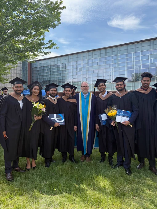 A photo of a group of graduates posing with Ontario Tech President Steven Murphy.
