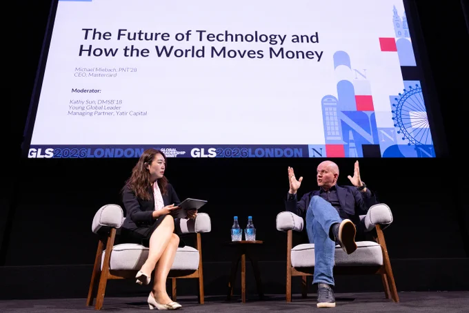 Two people on stage: panelist Michael Miebach (CEO of Mastercard), and moderator Kathy Sun, Northeastern alum and Managing Partner of Yetir Capital. Behind them, a screen displays 'The Future of Technology and How the World Moves Money'.