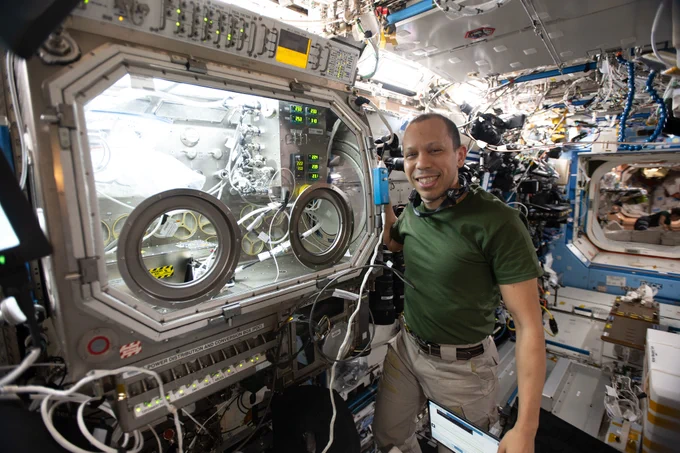 NASA astronaut and Expedition 74 flight engineer Chris Williams shows off the Destiny laboratory module’s Microgravity Science Glovebox aboard the International Space Station. WIlliams was supporting semiconductor crystal research to help advance the commercial space economy and promoting Earth-based industries.