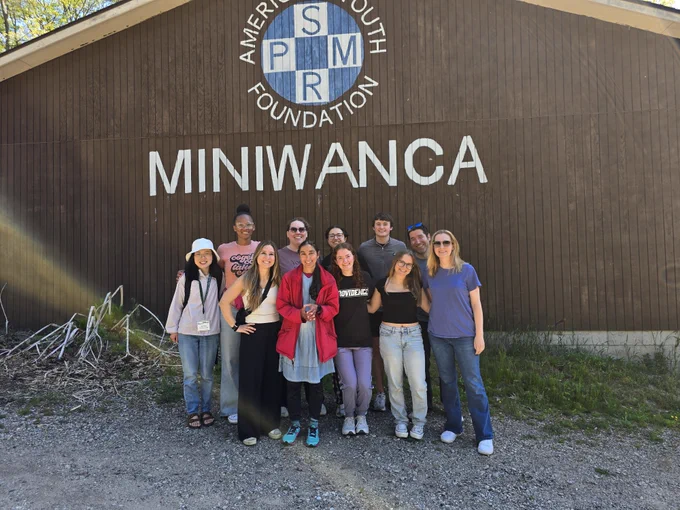 A group of people standing together in front of a building with "American Youth Foundation" and "MINIWANCA" on the facade.