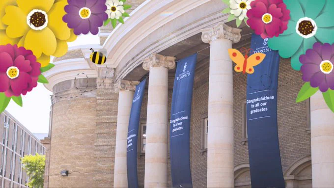 Outdoor spring photo of U of T Convocation Hall with long banners hanging between pillars. 
