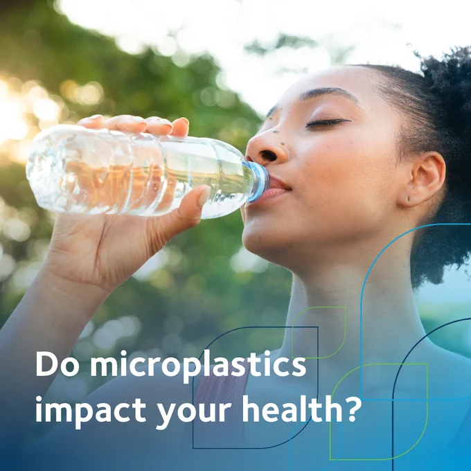A person drinks from a plastic water bottle outdoors. The background features green, blurred trees. Text on the image reads, "Do microplastics impact your health?"