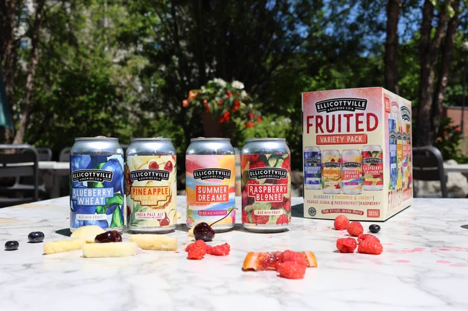 A variety pack of fruit-flavored beer. Blueberry Wheat Ale, Pineapple Upside Down Shake IPA, Summer Dreams Sour, Raspberry Blonde. There's a variety fruit dropped in front of 4 colorful beer cans & a box of the beer. 