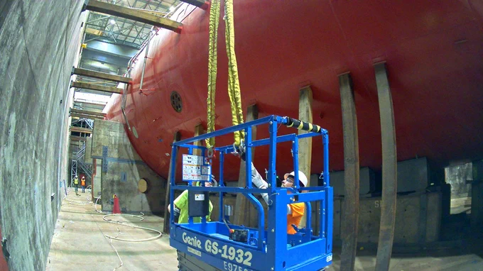 Demolition crew members sit inside the below-grade basin of the Submarine 5th Generation General Electric prototype, where they performed deactivation activities to prepare the prototype for demolition.