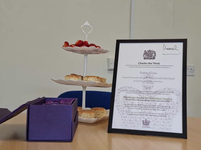 Kings' Award Certificate and a plate of scones on a table