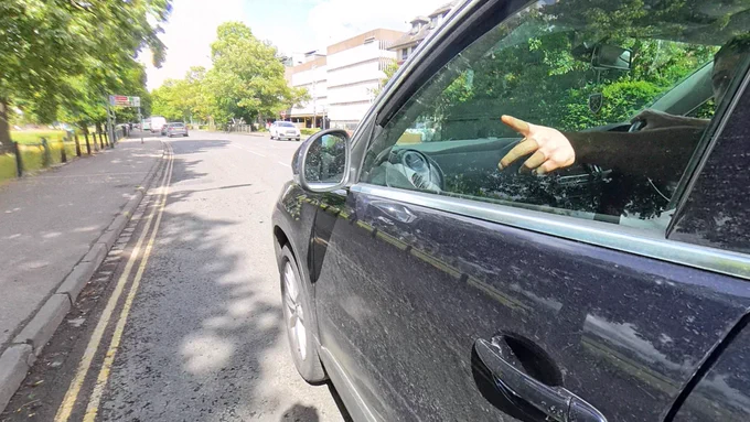 The driver pointing to what he believes is a cycle or shared path, wrongly.
