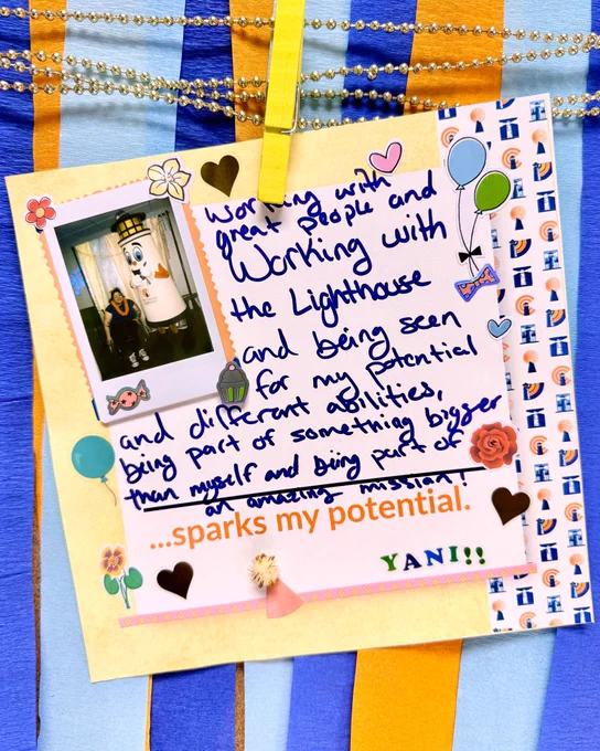 A  colorful scrapbook page with a handwritten note that reads “Working with great people and working with The Lighthouse and being seen for my potential and different abilities, being part of something bigger than myself and being part an amazing mission sparks my potential.” A small polaroid photo on the page shows Yani posing with lighthouse mascot, Ray L Beacon.