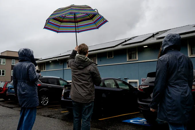 Staff look at the solar panels installed upon the YWCA Bellingham building