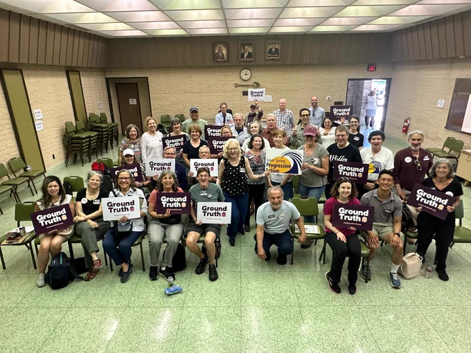 Group of volunteers holding signs getting ready to go canvass