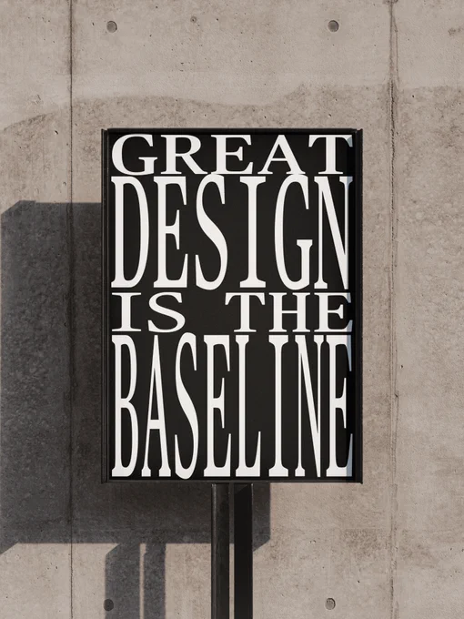 Bold text reads "GREAT DESIGN IS THE BASELINE" on a black background, displayed against a textured concrete wall.