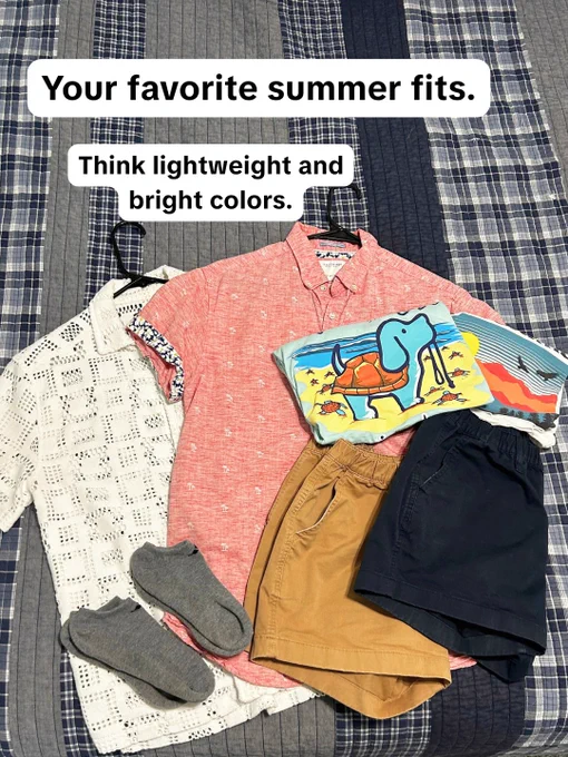 A collection of summer outfits is displayed on a checkered bedspread. The clothing includes a white short-sleeve button-up shirt, a coral short-sleeve button-up shirt, a T-shirt with a cartoon dog, beige shorts, dark shorts, and a pair of gray socks. Text on the image reads, "Your favorite summer fits. Think lightweight and bright colors.