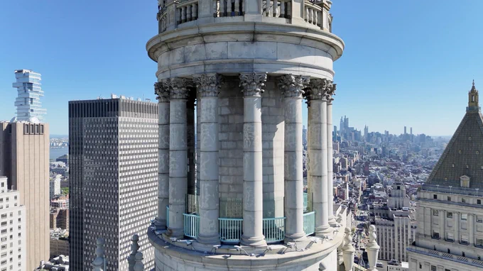 Exterior view of the restored Centre 360 cupola atop the David N. Dinkins Municipal Building, with panoramic views of Lower Manhattan and surrounding skyscrapers in the background.