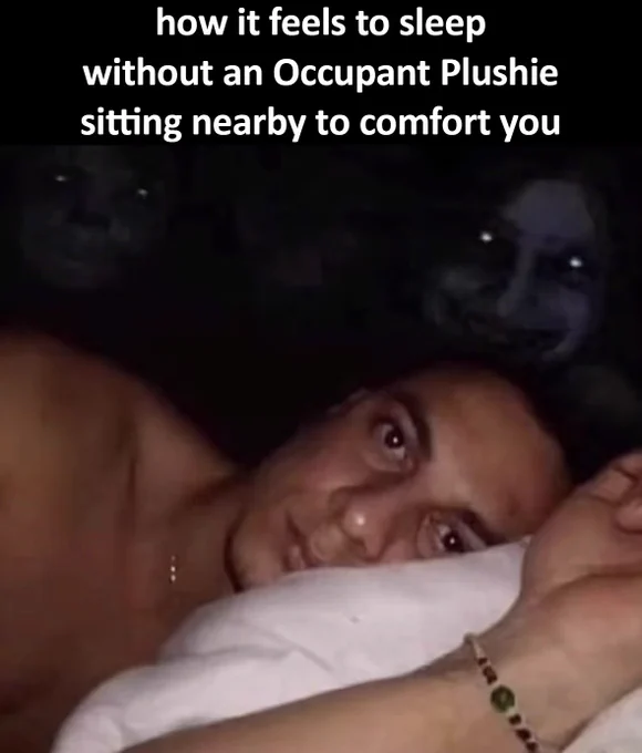 Meme of a guy sleeping on his side, facing toward the camera. Scawy spirits in the background in the dark are smiling in his direction. Text says: "how it feels to sleep without an Occupant Plushie sitting nearby to comfort you"