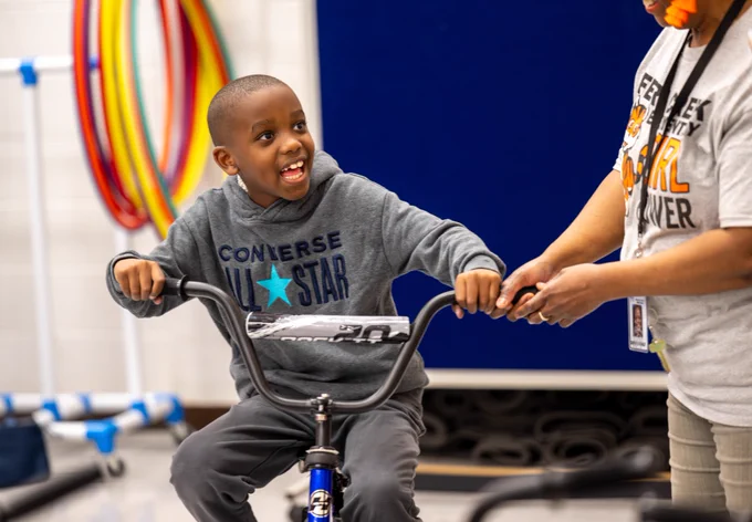 A student sits on a bike.