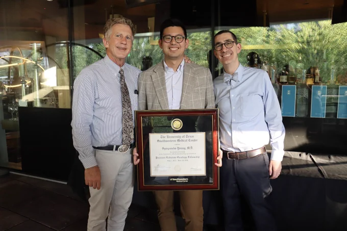 Dr. Sympascho Young holding his degree with Department leadership.