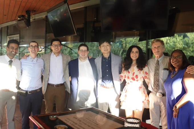 A group of resident graduates with residency leadership.