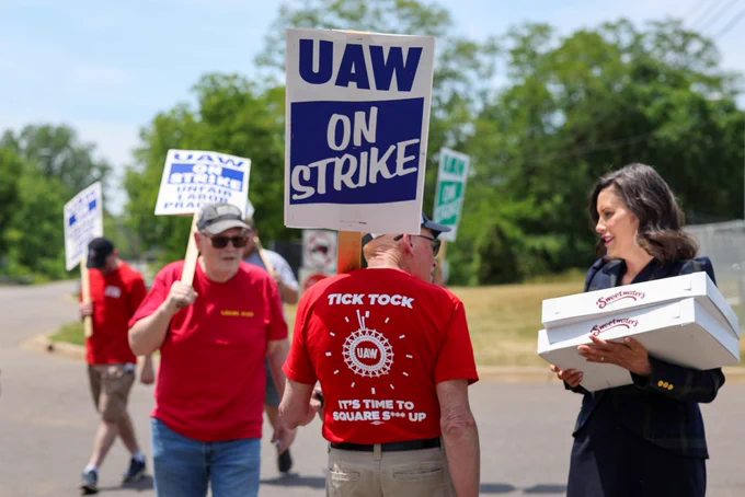 Gov. Whitmer holds food item during workers strike.