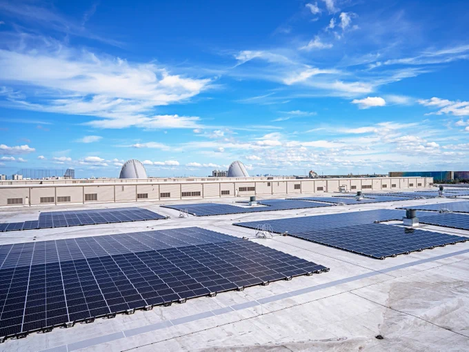 The Orange County Convention Center North-South Building rooftop solar array, under a bright blue sky with scattered clouds. 