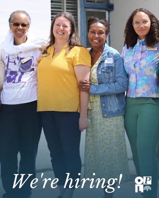Four people standing together, smiling at the camera in a friendly manner. They are dressed in casual, colorful clothing. Text at the bottom says, "We're hiring!" with the OP logo next to it.
