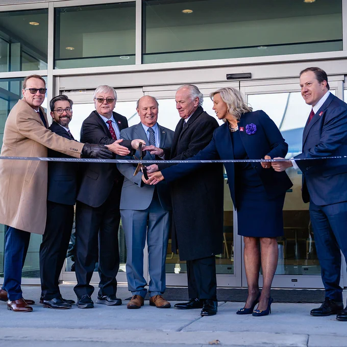State and university officials cut the ribbon on the University of South Carolina Brain Health Center in March 2026. The image shows seven individuals standing together behind a branded USC Brain Health ribbon, holding large scissors poised to cut the ribbon on the new facility. Pictured from left to right are USC VP for Research Julius Fridriksson, USC Floyd School of Medicine Senior Associate Dean for Research Leo Bonilha, USC President Michael Amiridis, South Carolina Senate President Thomas Alexander, South Carolina Governor Henry McMaster, USC Brain Health patient caregiver Laura Haynes and USC Board of Trustees Chair Thad Westbrook.