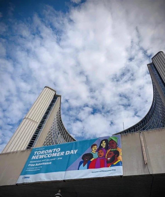 Newcomer Day banner with City Hall in the background.