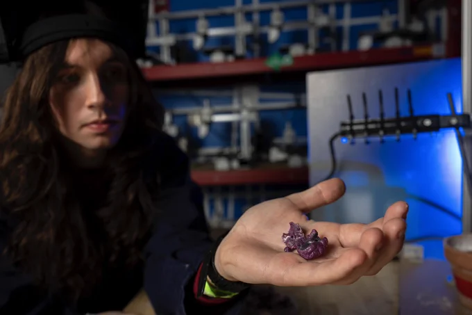 Jonathon (Jack) Bender in a Makerspace in Benedum Hall holding two synthetic rubies he created.