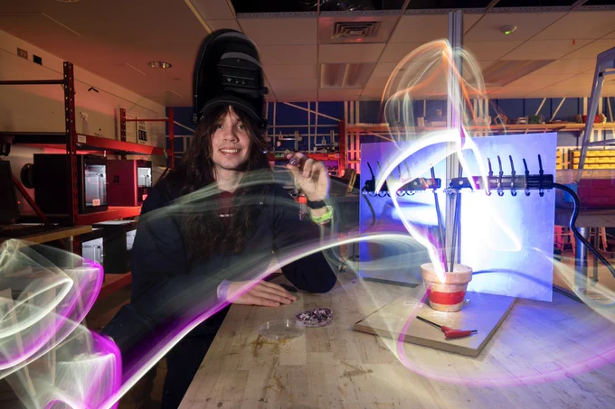 Jonathon (Jack) Bender in a Makerspace in Benedum Hall holding a synthetic ruby he created.