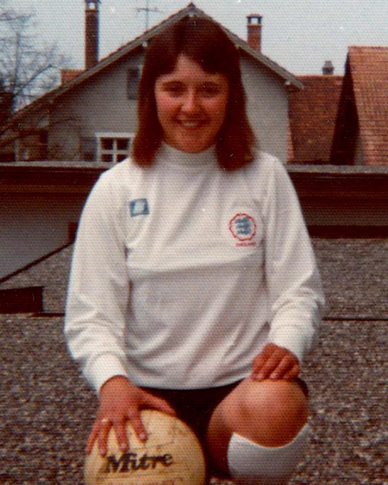 England player Carol Thomas in her kit with a football. 
