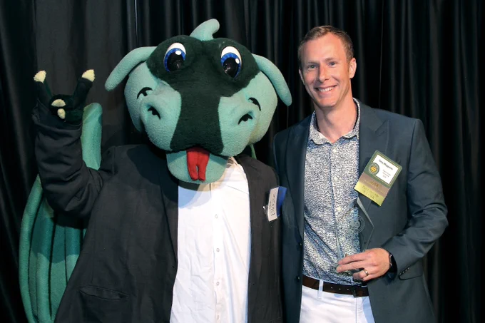 dragon mascot posing with a business owner and award winner