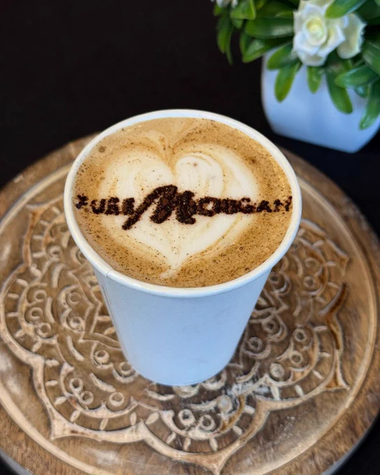 Latte art in a coffee cup with the words Pure Michigan written on top