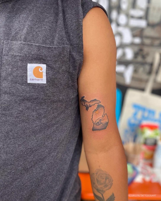 Person with a Michigan-shaped tattoo on their arm