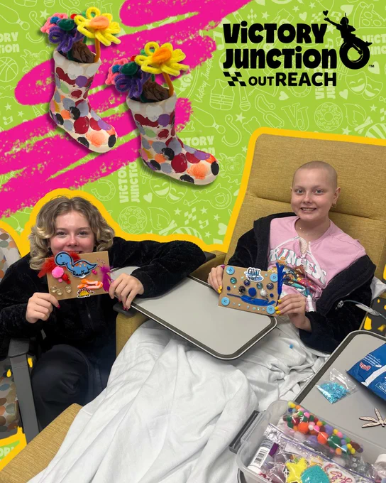 Two patients smiling at the camera while they are holding their crafts.