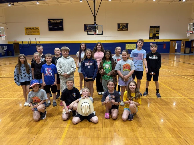 Students stand smiling at the Bad Axe Middle School SHARP Assembly. 