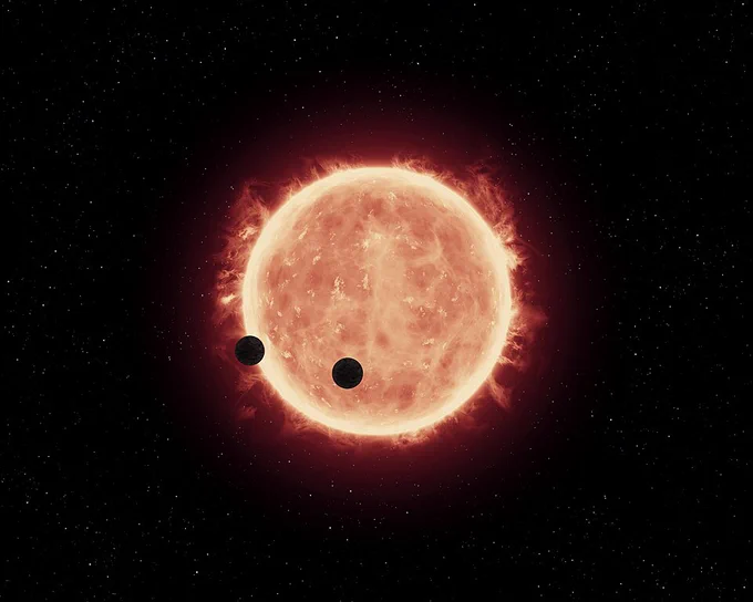 This artist's impression shows two Earth-sized worlds passing in front of their parent red dwarf star, which is much smaller and cooler than our Sun. The star and its orbiting planets TRAPPIST-1b and TRAPPIST-1c reside 40 light-years away. The planets are between 20 and 100 times closer to their star than Earth is to the Sun. Researchers think that at least one of the planets, and possibly both, may be within the star's habitable zone, where moderate temperatures could allow for liquid water on the surface. Hubble looked for evidence of extended atmospheres around both planets and didn't find anything,