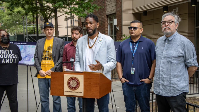 The Public Advocate speaks at a press conference outside of Grand Street Guild, as staff members and advocates listen