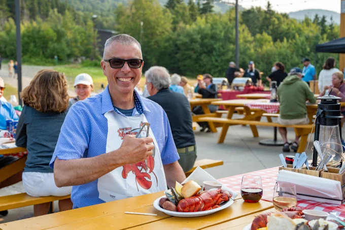 A man smiling during the lobster bake at North Peak.