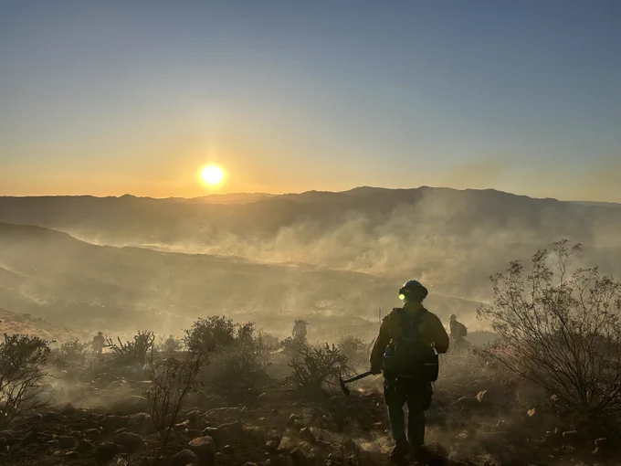 Wildland firefighter in a smoky outdoor landscape. 